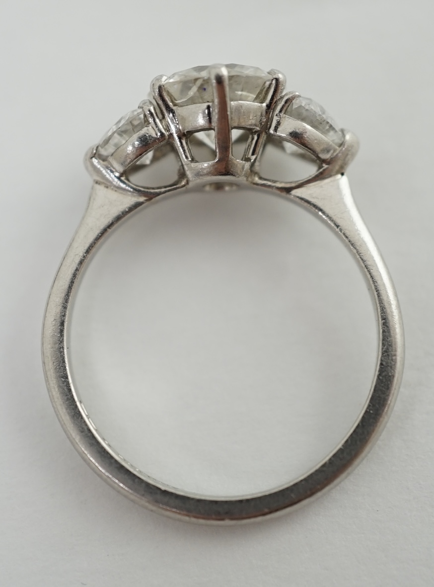 A modern Boodles & Dunthorne platinum and single stone diamond ring, with two stone heart shaped diamond set shoulders